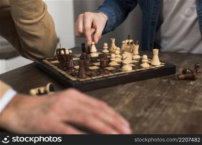 close up father son playing chess