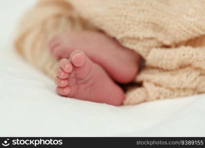 close up feet of newborn baby on a bed