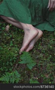 Close up feet on green forest ground concept photo. Conceptual style. Top view photography with moss on background. High quality picture for wallpaper, travel blog, magazine, article. Close up feet on green forest ground concept photo