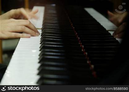 close-up female hand playing grand piano