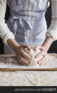 close up female kneading dough with flour