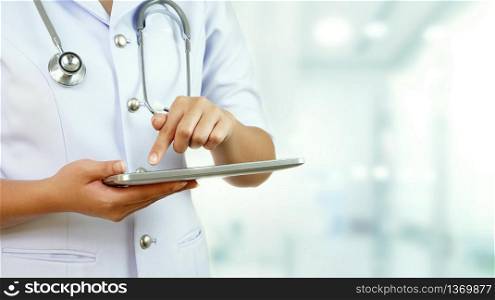 Close up female nurse with stethoscope using tablet and blurred hospital area background, technology and medical health care concept