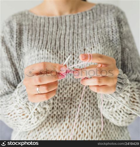close up female s hand crocheting with pink thread