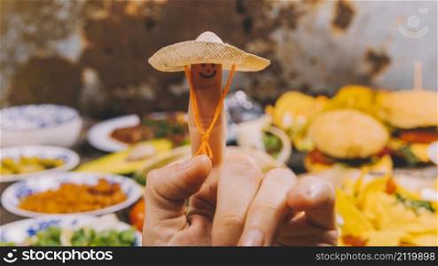 close up finger art with small hat mexican food background
