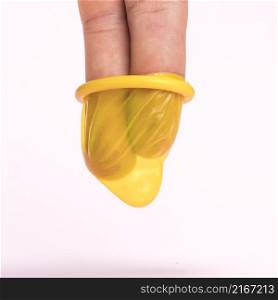 close up fingers yellow condom