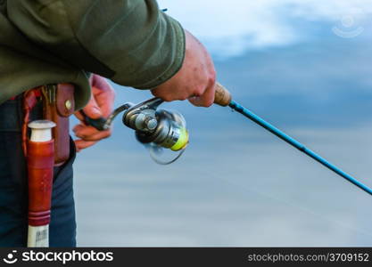 Close-up, fisherman casts a lure on the lake, horizon format image