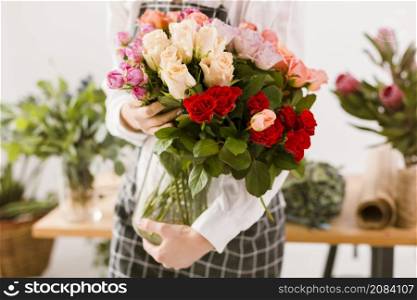 close up florist holding jar with flowers