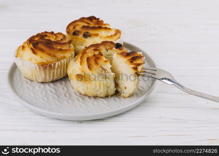 close up fork cupcake plate wooden backdrop