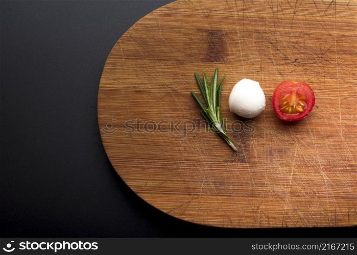 close up fresh cheese rosemary half tomato chopping board