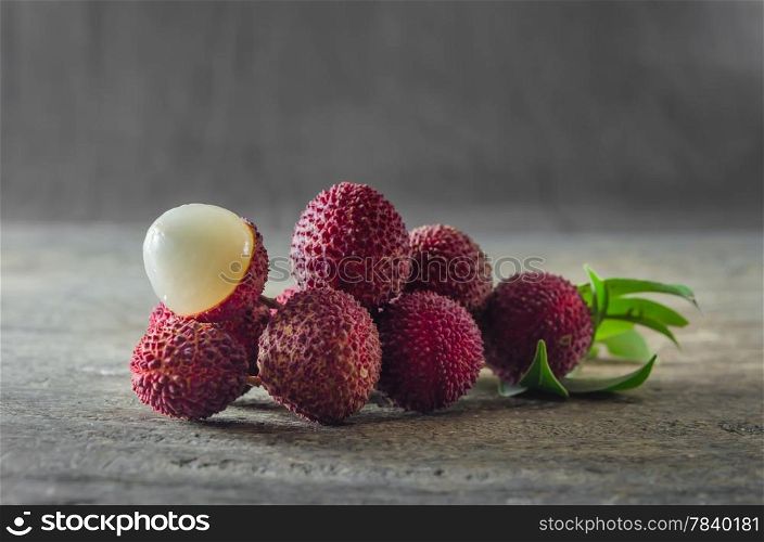 close up fresh Lychee with leaves on a wooden table. Lychee fruit