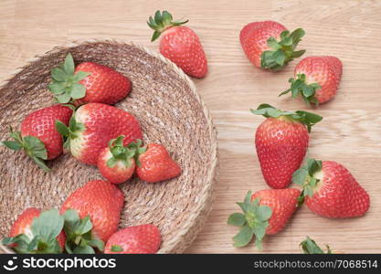 close up fresh strawberries with natural wood background in a basket