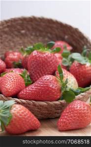 close up fresh strawberries with natural wood background in a basket
