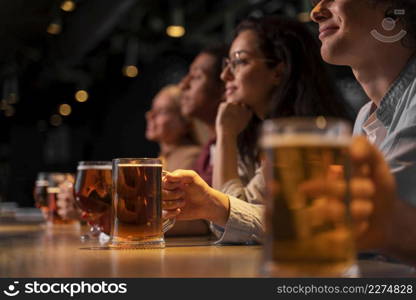 close up friends holding beer mugs