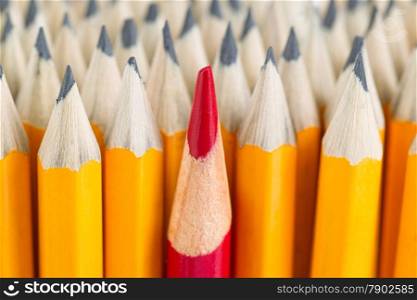 Close up front image of stacked pencils with focus on tip of red pencil in middle of the stack