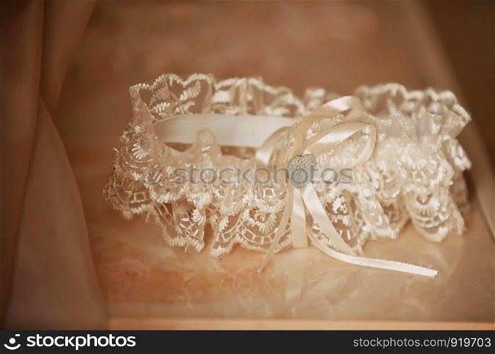 close up garter setup shot on top of the veil, bride's getting ready. morning preparation wedding concept. close up garter setup shot on top of the veil, bride's getting ready. morning preparation wedding concept.