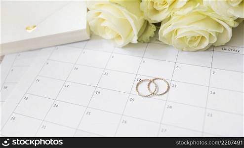 close up gift box roses wedding rings calendar