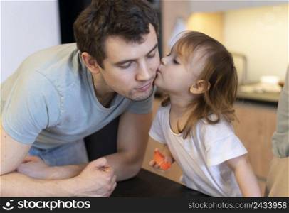 close up girl kissing father cheek