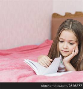 close up girl lying bed reading book