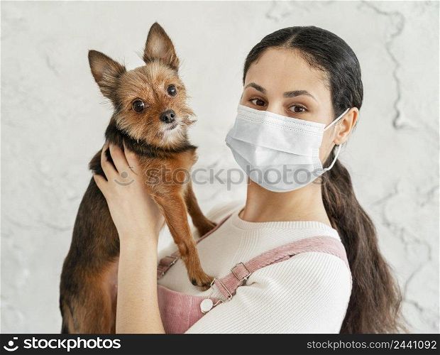 close up girl with mask holding dog