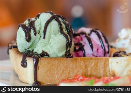 close up green ice cream with honey toast and whipping cream with chocolate sauce . honey toast and ice cream