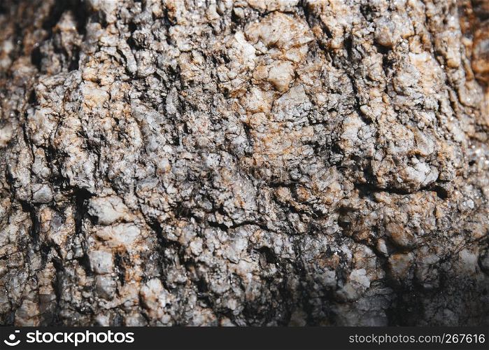 Close-up grungy rock textured with tiny glitter and shiny sharp pieces on the surface detail. Natural abstract background.