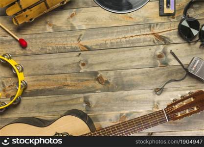 close up guitar headphone tambourine xylophone headphone radio wooden table with space text. Beautiful photo. close up guitar headphone tambourine xylophone headphone radio wooden table with space text