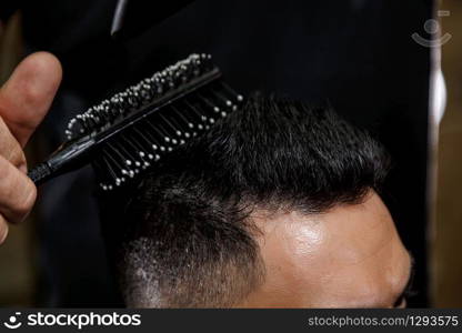 close-up haircut of a dark-haired guy. cinematic photography.