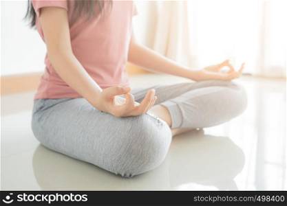 Close up hand and half body of healthy woman sit in lotus Yoga position.Young healthy woman sitting posture exercise in home.Concept of meditating,lifestyle and relaxation.