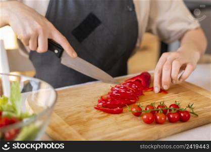 close up hand cutting pepper