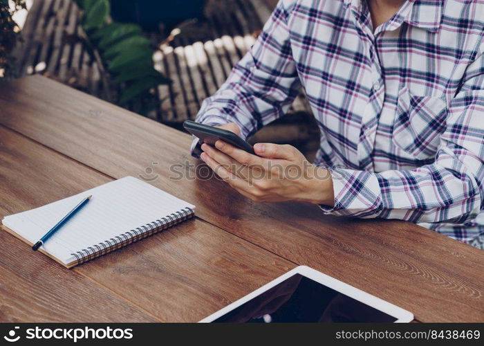 Close up hand female holding phone and working in cafe restaurant.