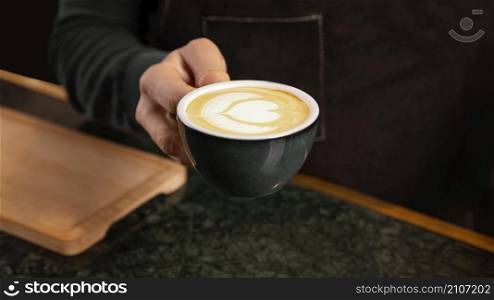close up hand holding coffee with milk cream