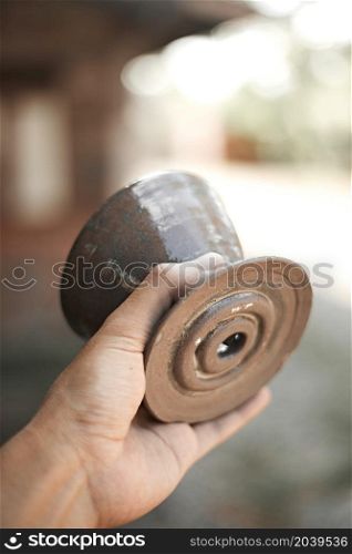 Close up hand holding dripper ceramic on blur background. Close up hand holding dripper ceramic