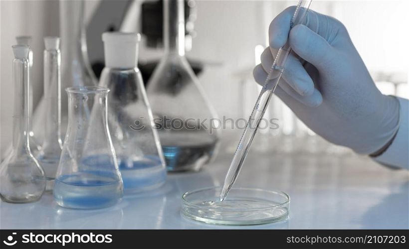 close up hand holding lab pipette