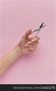 close up hand holding nail scissors