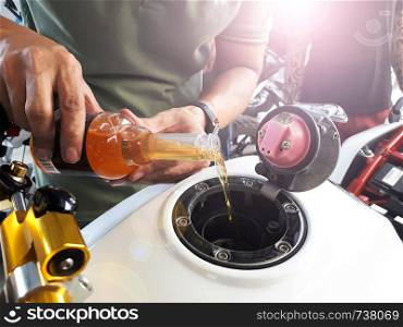 Close up hand holding oil bottle, bigbike maintenance work