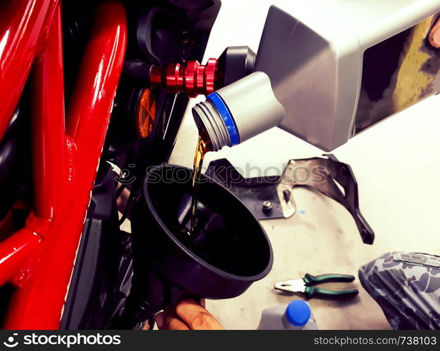 Close up hand holding oil bottle, bigbike maintenance work