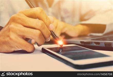 Close up hand holding pen touch on mobile screen work from home