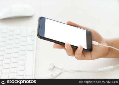 close-up hand holding phone mobile showing white screen on desk