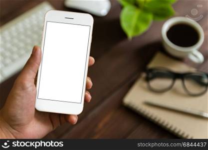 close up hand holding phone over work table, mockup phone blank screen for app screen adjustment