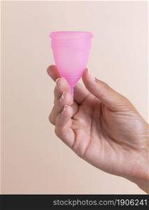 close up hand holding pink menstrual cup. High resolution photo. close up hand holding pink menstrual cup. High quality photo
