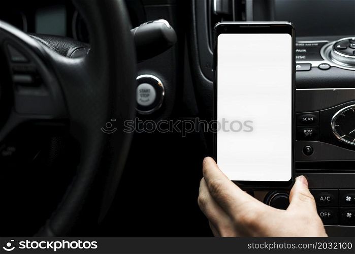 close up hand holding smart phone showing white blank screen car