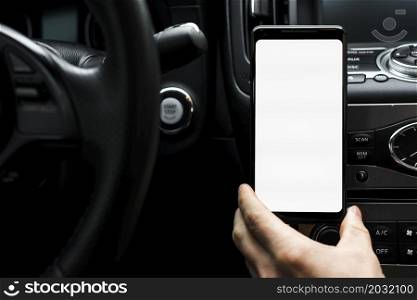 close up hand holding smart phone showing white blank screen car
