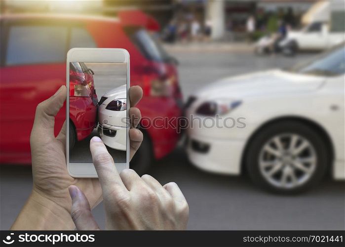 Close up hand holding smartphone and take photo at The scene of a car crash and accident, car accident for car insuranc claim.
