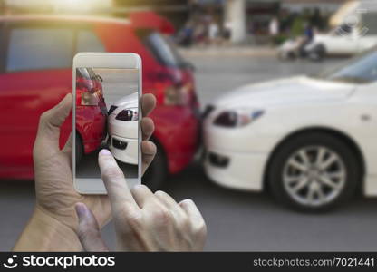 Close up hand holding smartphone and take photo at The scene of a car crash and accident, car accident for car insuranc claim.