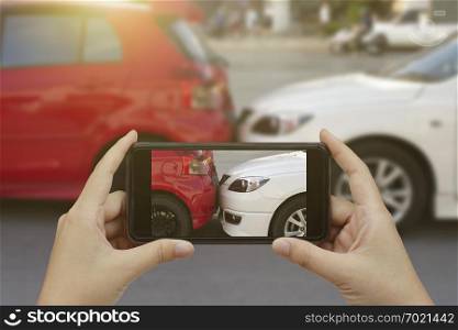Close up hand holding smartphone and take photo at The scene of a car crash and accident, car accident for car insuranc claim.