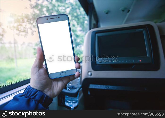 Close-up Hand holding smartphone blurred images touch of World figure tourism road trip concept in Abstract inside of LCD screen blank rear seat on the bus for entertainment the bus Blurred background