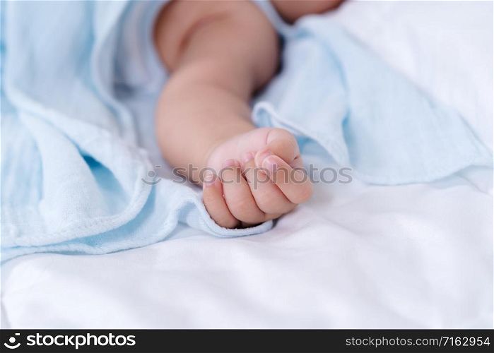 close up hand of baby on a bed