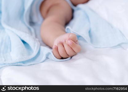 close up hand of baby on a bed