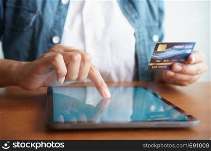 Close up hand of businessmen are buying online with a credit card. Men are using tablet and doing online transactions.