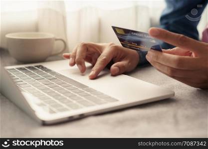 Close up hand of businessmen are buying online with a credit card. Men are using laptop and doing online transactions.